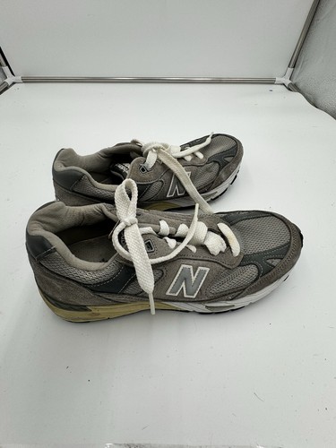 Grey New Balance 991 size 7 with white laces, tan midsole, and large white “N” logo on side.