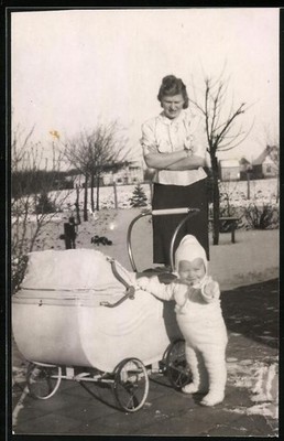 Fotografie Mutterglück, Mutter nebst stehendem Baby am Kinderwagen 