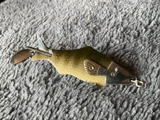 A VINTAGE PFLUEGER PIPPIN WEEDLESS FISHING LURE.