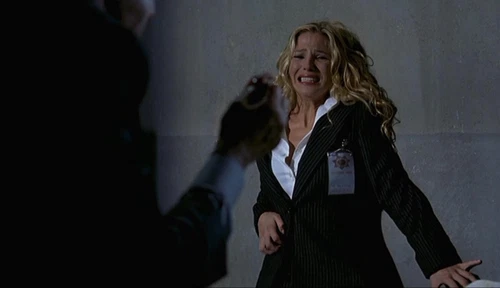 Hand reaches toward woman in white suit with blonde hair, shouting, “ELSA PATAKY” as black zombies approach.