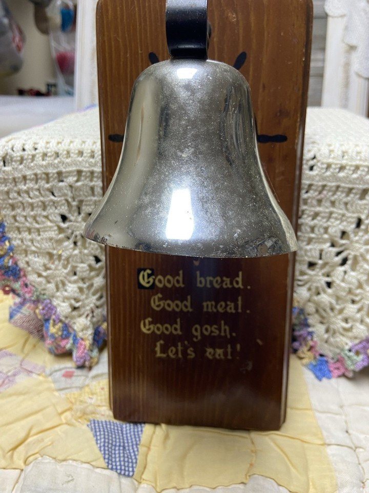 A chunky vintage wood dinner bell sign that literally yells 'Let's Eat' — functional farmhouse kitsch with genuine old-school charm.