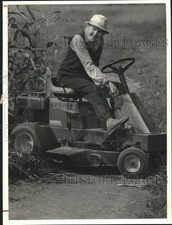 Press Photo A man sitting on a lawn mower - sya93683