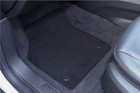 Black 4-piece Pontiac Bonneville Safari floor mat with textured loops, resting on a gray fabric-lined car interior.
