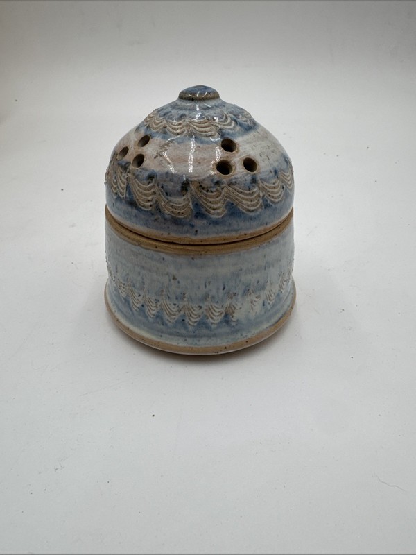 studio art pottery garlic keeper or jar designed with ventilation holes.