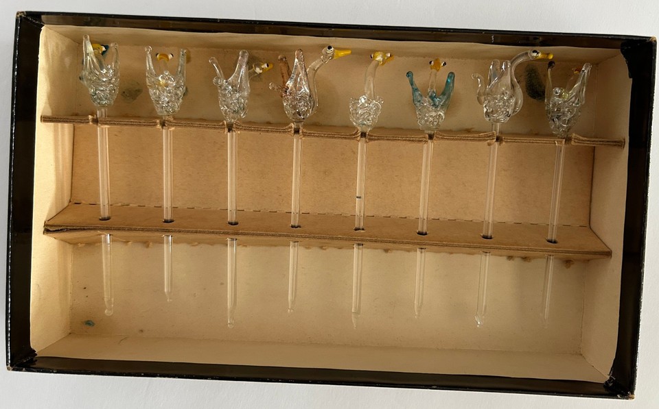Hand-blown glass swans perched on cocktail stirrers — a set of 16 that turns any drink into a tiny art installation.