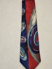 Red necktie with blue and gray abstract swirl pattern, silver buttons, and “Made in U.S.A.” label on white surface.
