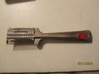Vintage silver hair cutter with red handle, black case, and engraved text “Made in U.S.A.” on side handle.