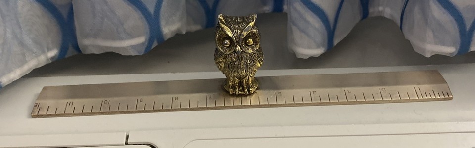 A 2.5" brass owl perched atop a miniature ruler — absurdly charming MCM desk sculpture that doubles as a teacher-gift cliché done right.