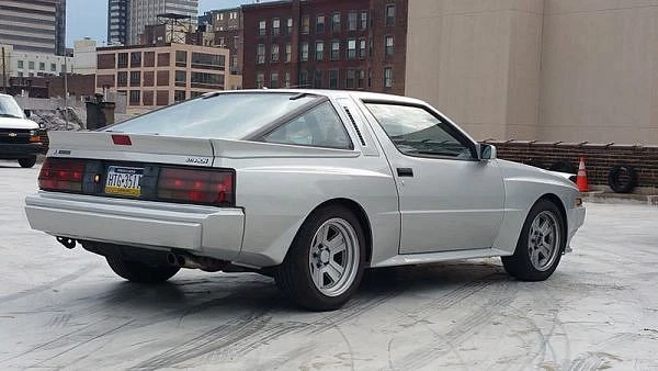 A grey Mitsubishi Starion ESI with a wide body flare sitting in a parking lot 