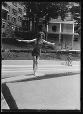 Photo:Woman on diving board at swimming pool