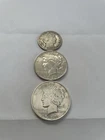 2 Silver Peace Dollars And One Barber Half Dollar.