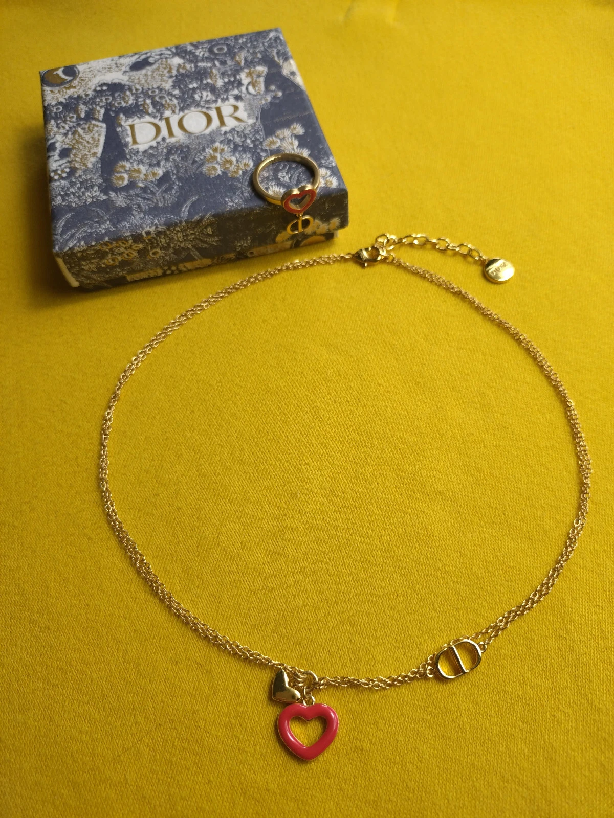 Collier et bague Dior dorés assortis coeur rouge