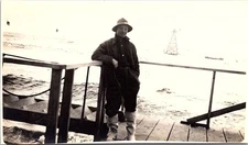 Fisherman on Boat Deck in Coat and Hat, Ocean Tower Behind RPPC Postcard