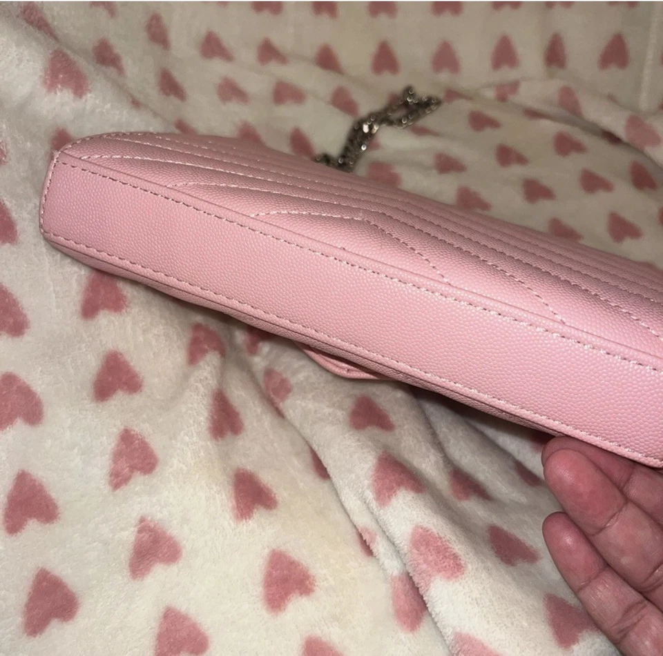 Bandolera de cuero sobre acolchado rosa con herrajes plateados.' Foto 4 de 4