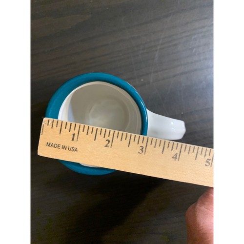Teal green ceramic coffee mug with white ribbed bee, shown beside a wooden ruler measuring 3 inches tall.