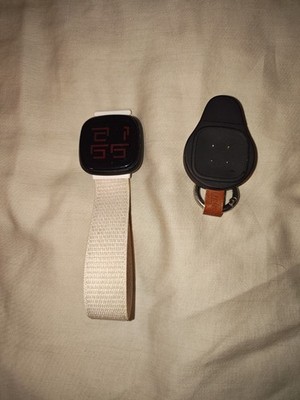 Fitbit Versa 4 Smartwatch 40 mm schwarz, beiges Nylonarmband, Ladekabel