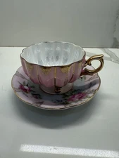 VINTAGE PORCELAIN TEACUP AND SAUCER OPALESCENT PINK THREE FOOTED CUP.