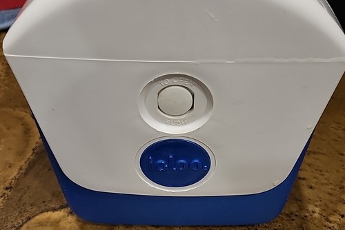 White rectangular Igloo cooler with black top, blue side panel, and white circular opening button.