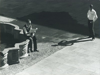 Photo Partial View of a Square with Fountain, Man Reading Newspaper - 10937829