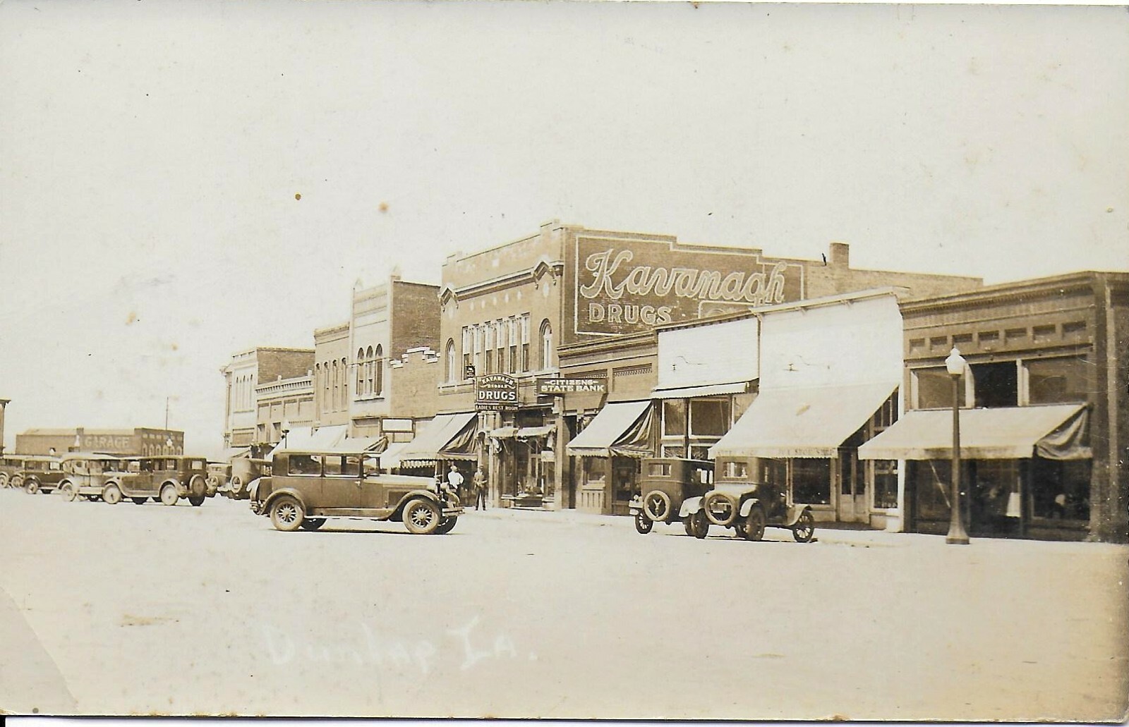 2 RPPCs Street Scenes in Dunlap Iowa 192030s w/ Autos and Businesses