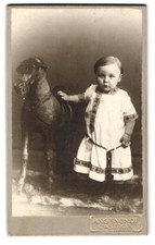 Fotografie Angenendt, Castrop, junger Knabe im Kleid nebst Schaukelpferd 