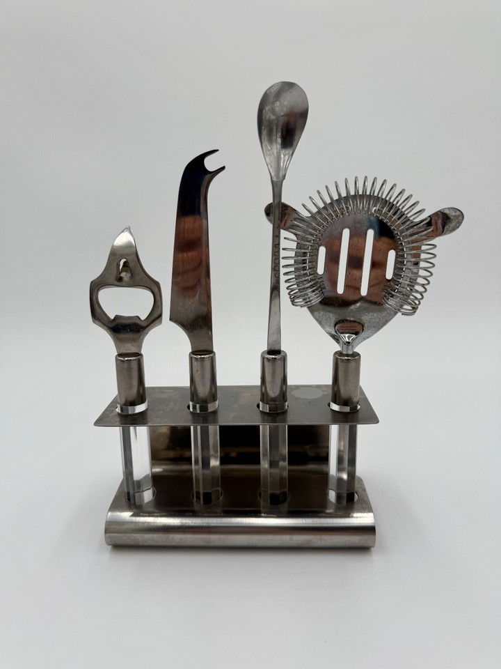 A sleek mid-century Rostfrei stainless-and-lucite cocktail utensil set — the kind of design-forward barware that belongs in a museum as much as a home bar.