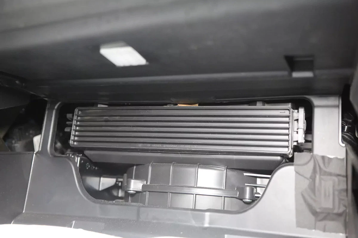 The cabin air filter access door located behind the vehicle's glove box.