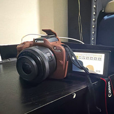 Canon EOS r50 mirrorless camera body with brown case and lens canon