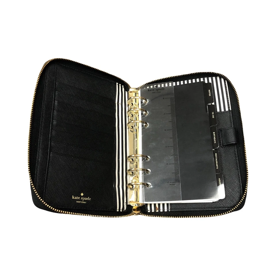 Planificador Kate Spade con "JR" y pajarita en la espalda con regla y papeles Foto 3 de 4