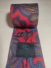 Red ETRO silk tie with yellow, blue, and paisley pattern, featuring small black square with white bird logo on necktie.