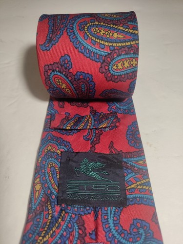 Red ETRO silk tie with yellow, blue, and paisley pattern, featuring small black square with white bird logo on necktie.