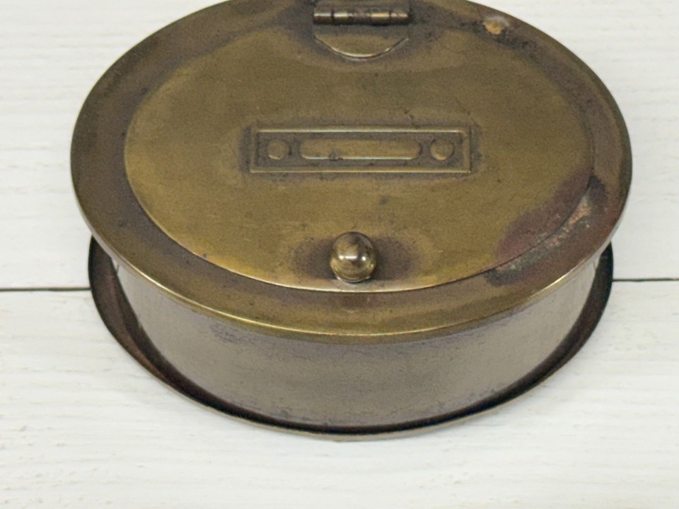 Art Deco brass inkwell with a hinged lid and ball feet — a tiny sculptural object that makes any desk feel like a 1920s novelist's study.