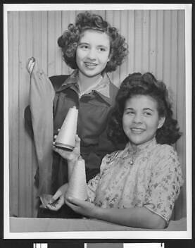 two female garment workers holding two spools of thread and fabric - Old Photo