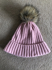 Cappello in maglia rosa scuro con bobble peloso, indossato una volta