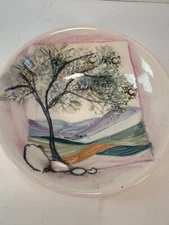 Handpainted ceramic dish features landscape scene with a tree in the foreground