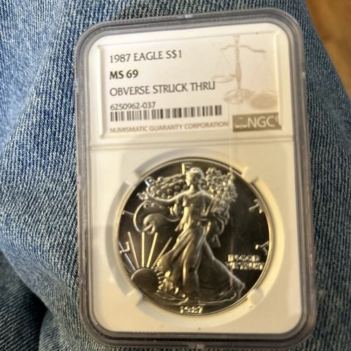 1987 American Silver Eagle – Mint Error Obverse Struck Thru – NGC MS69