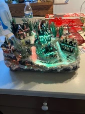 Avon light up christmas village scene. Works. Hills of water flowing. Skaters.