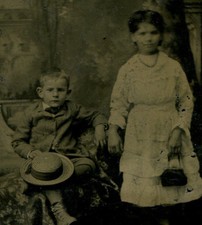 YOUNG BOY HOLDING HAT, YOUNG GIRL HOLDING PURSE. TINTED TYPE.