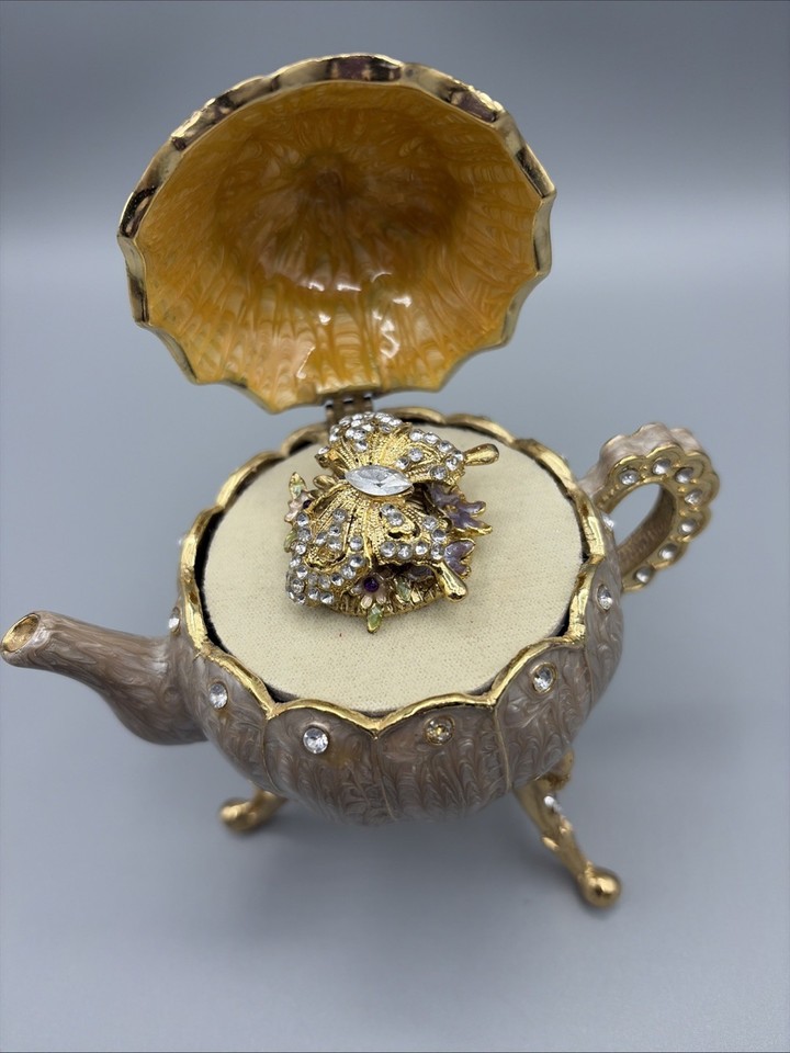 Crystal-jeweled enamel butterfly teapot that plays music — a maximalist, glam little object that straddles art piece and functional curiosity.
