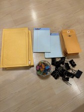 Duże wyściełane koperty, małe koperty, duże i małe klipsy do segregatorów, 2 podkładki do pisania