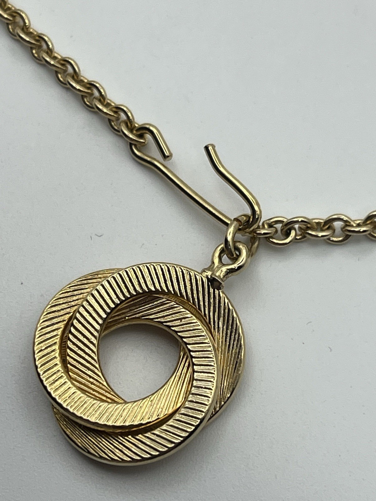 Engine turned gold tone triple interlocking circl… - image 11