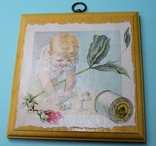 Baby playing with a spool of thread on wood