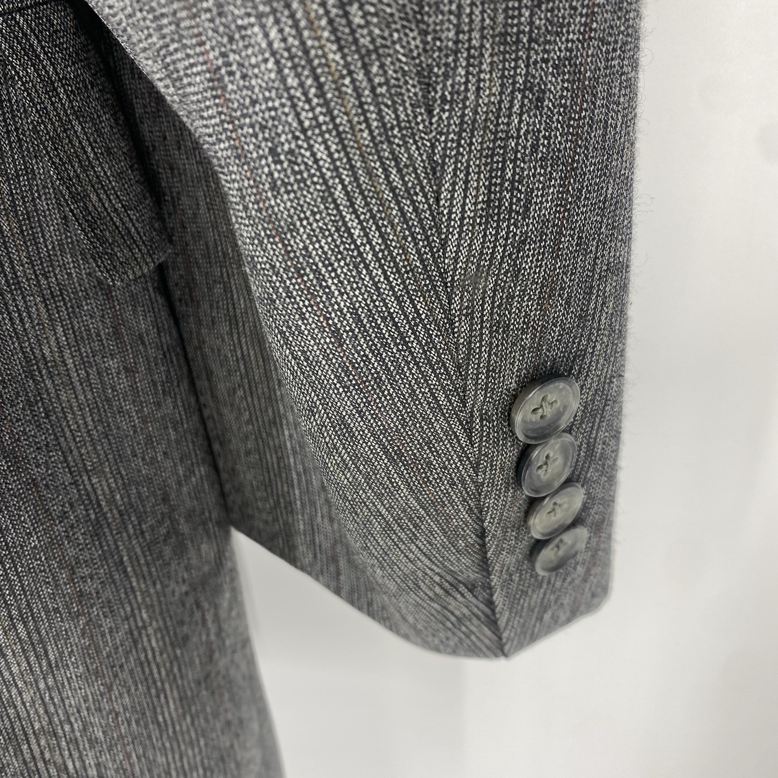 Vintage Christian Dior grey suit jacket with textured fabric, three-button front closure, and long sleeves.