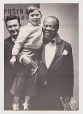 Louis Armstrong: Jazz Icon Holds a Child in One Hand Trumpet in the Other Photo