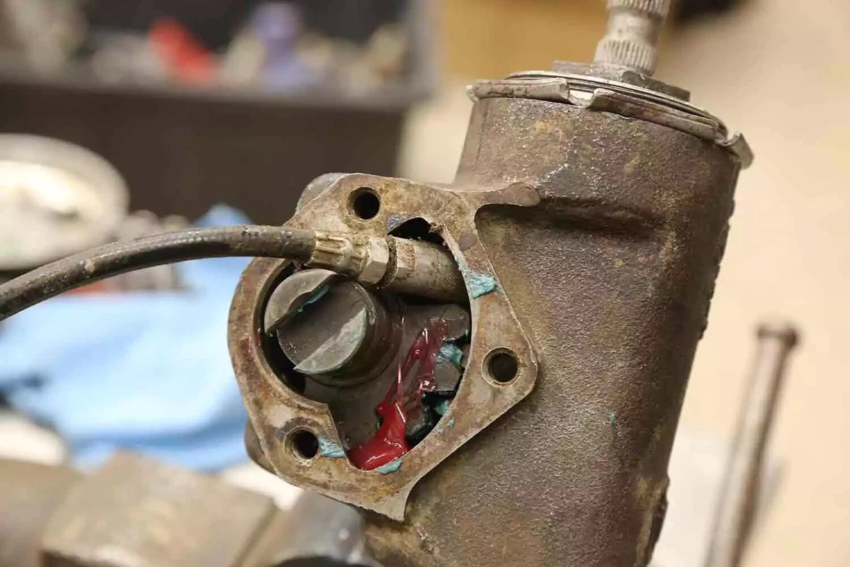 A close-up view of an open steering box, with red grease on its internals.