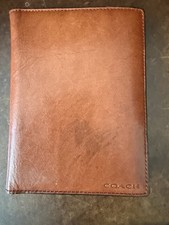 Estuche tipo billetera Coach con soporte para pasaporte de cuero coñac