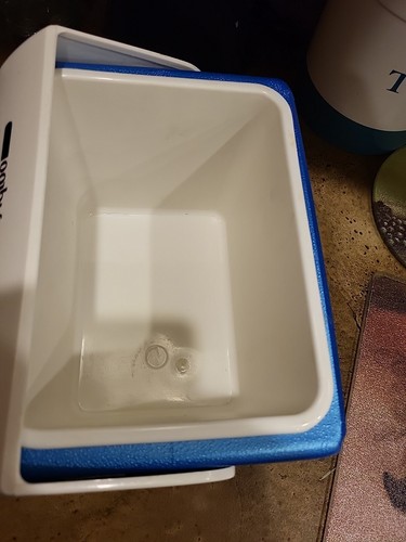 White rectangular Igloo cooler with blue top and sides, made in U.S.A., showing interior water level.