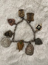 Pulsera vintage con dije de medalla de corredor y relé de una milla algunos datados en la década de 1950’s