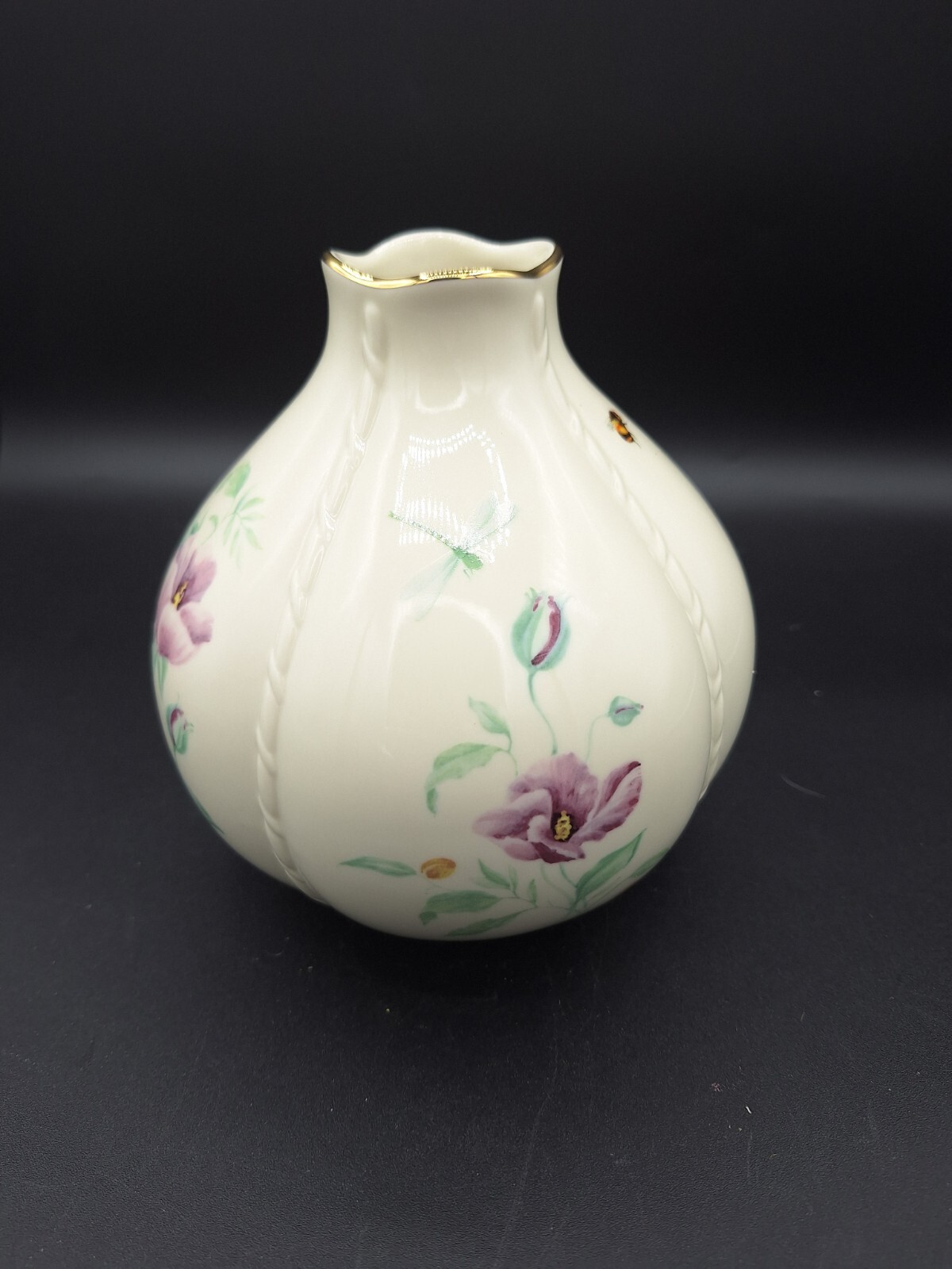 Cream round LENOX MORNINGSIDE vase with gold rim, purple floral accents, and green leaves on a dark background.