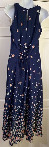 Navy blue midi dress with small white floral print, lace-up front detail, and scoop neckline on mannequin.